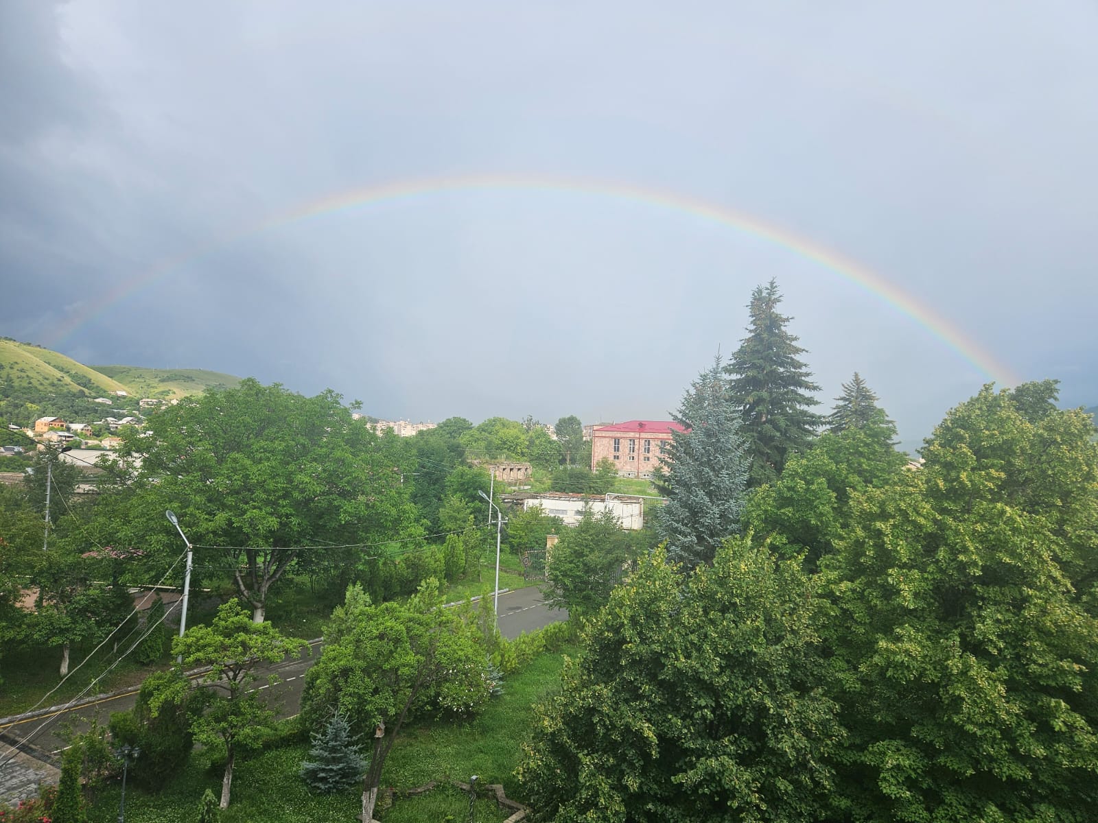 A colorful rainbow stretching over the green hills of Vanadzor valley