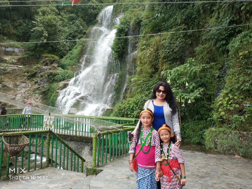 Bakthang Waterfall in Gangtok with traveler and local Sikkimese children in traditional dress