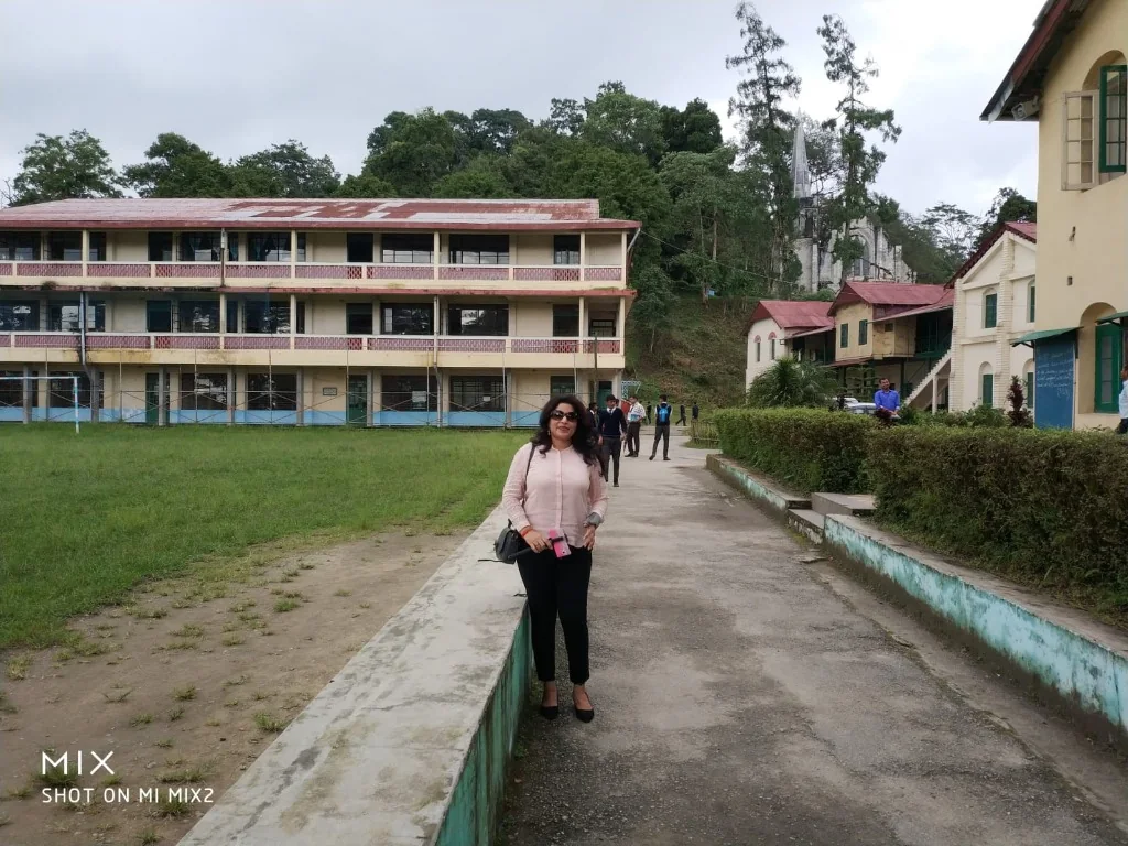 A woman standing on a paved pathway at Dr. Graham's Homes school campus