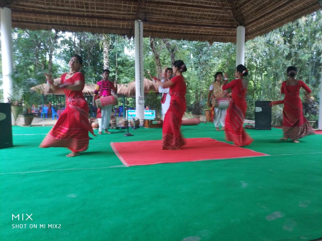 Assamese dancers performing in traditional red attire at Kaziranga Cultural & Bio-Diversity Park