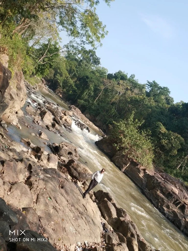 Pobitora forest stream flowing through rocky landscape
