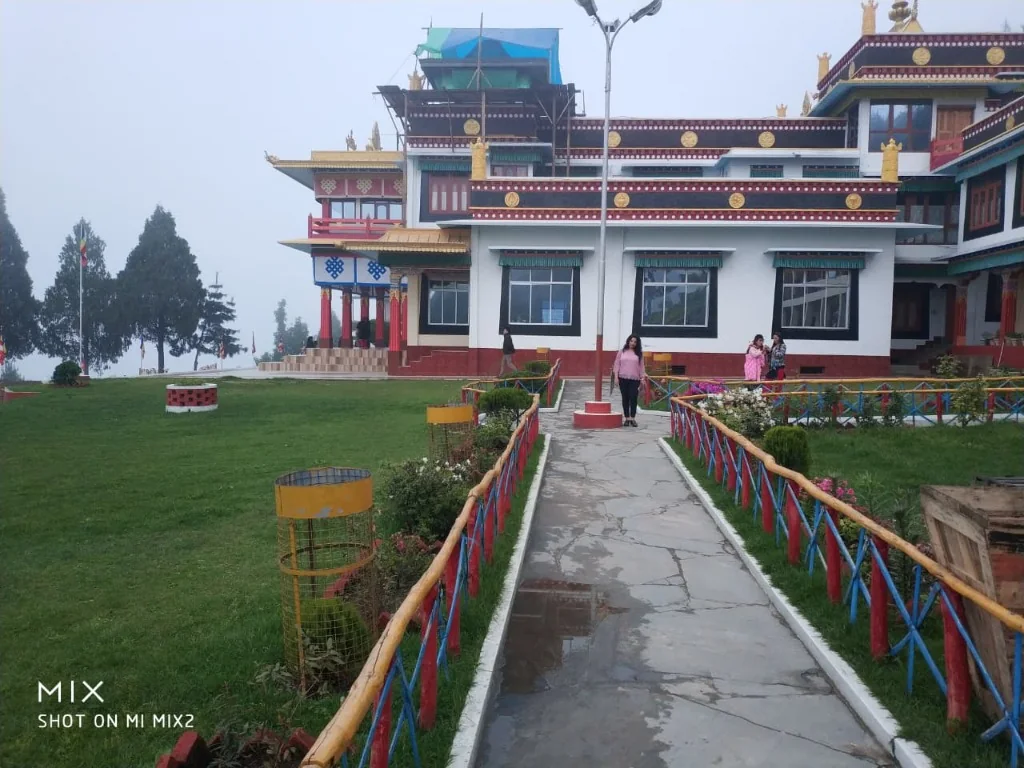 Mist-covered lawn pathways and Tibetan architecture of Bomdila Monastery