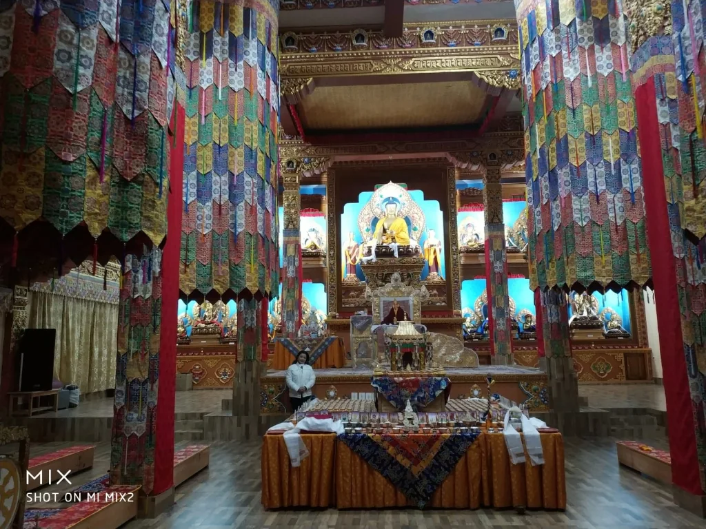 Ornate silk banners and golden altar inside Thupsung Dhargye Ling Monastery