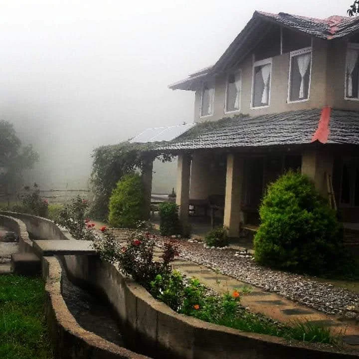 A small channel of clear mountain water running directly next to the traditional cottage at Mud House Homestay