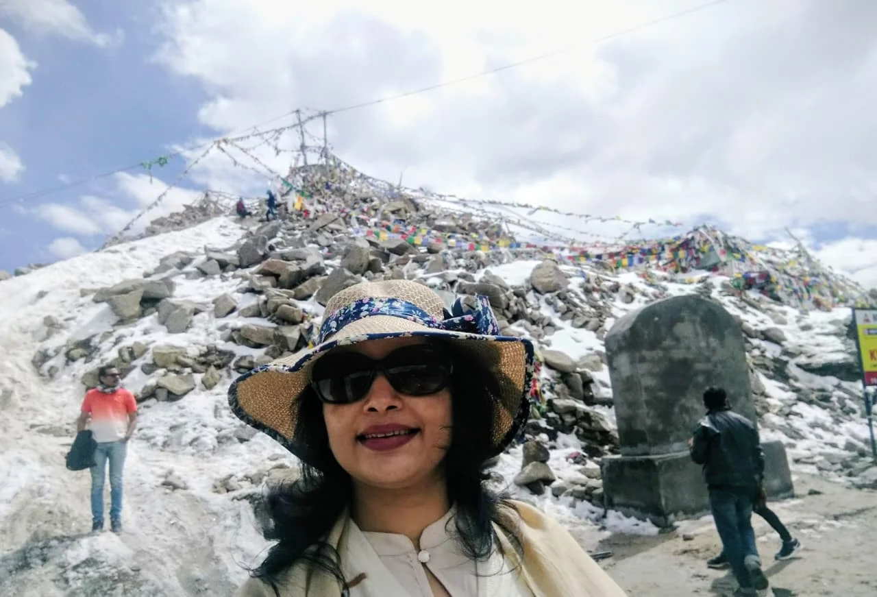 At Khardung La Pass with snow-covered mountains