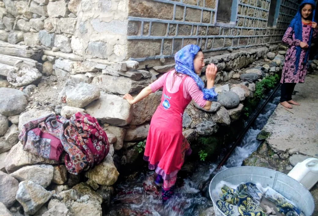 Local woman washing clothes in a stream in Turtuk village.
