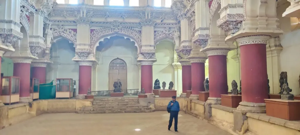 Historic inner hall with red pillars and Dravidian-Islamic arches