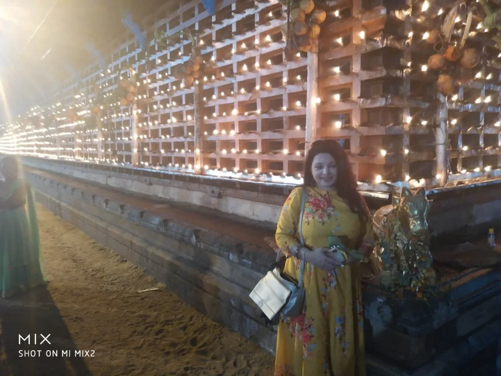 Standing in front of the illuminated temple lamps