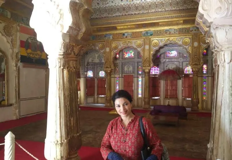 Ornate Rajput palace hall with carved pillars and stained glass in Jodhpur