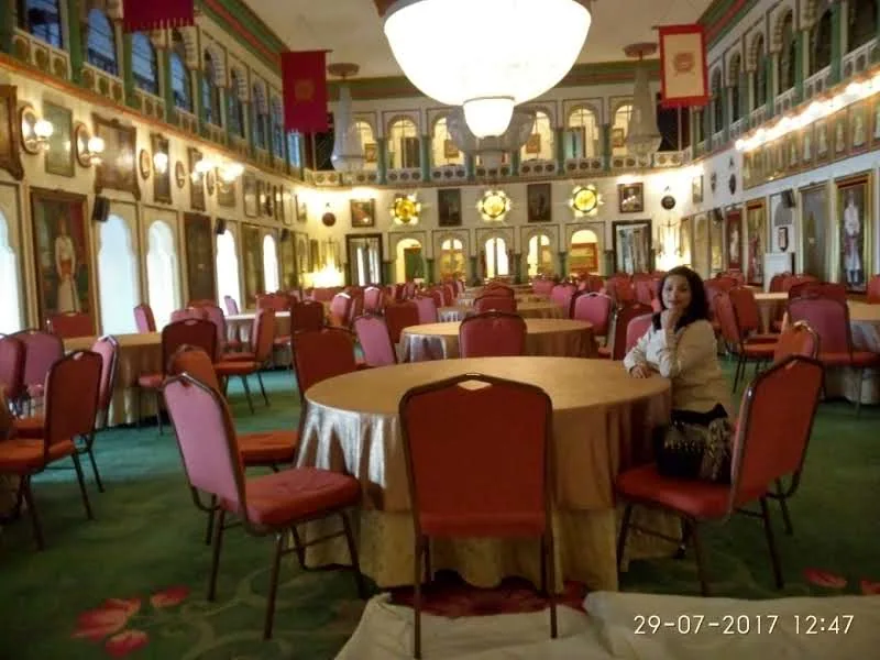 Grand interior of Durbar Hall at Fateh Prakash Palace showing crystal chandeliers, royal portraits, and red velvet seating
