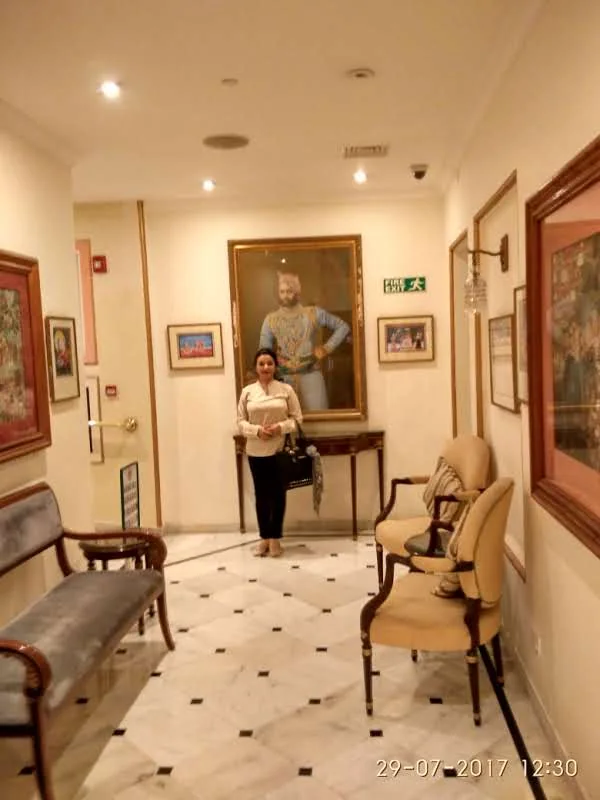 Luxury heritage corridor at Fateh Prakash Palace displaying oil portraits of Mewar Maharanas